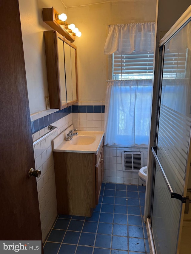 bathroom featuring visible vents, toilet, tile walls, tile patterned flooring, and vanity