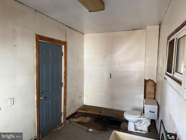 bathroom featuring toilet and concrete flooring