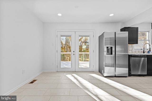 interior space with visible vents, light countertops, appliances with stainless steel finishes, french doors, and dark cabinetry