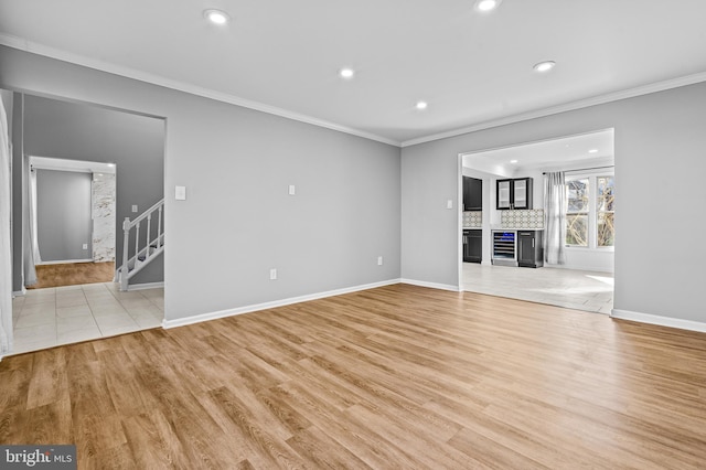 unfurnished living room featuring recessed lighting, ornamental molding, stairs, and light wood finished floors