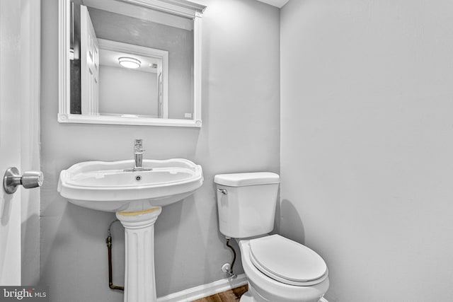 bathroom featuring baseboards, toilet, and wood finished floors