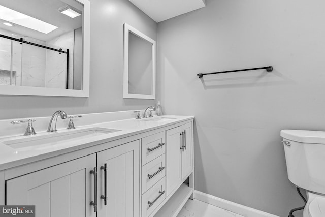 full bathroom featuring a marble finish shower, baseboards, toilet, marble finish floor, and a sink