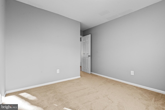 carpeted empty room with baseboards