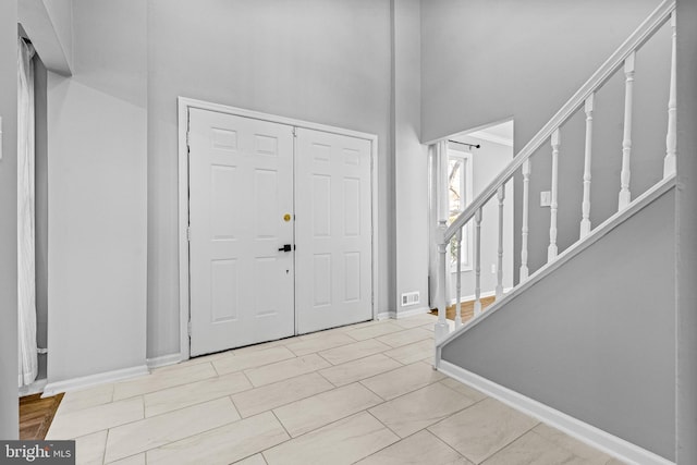 entryway with visible vents, baseboards, and stairway