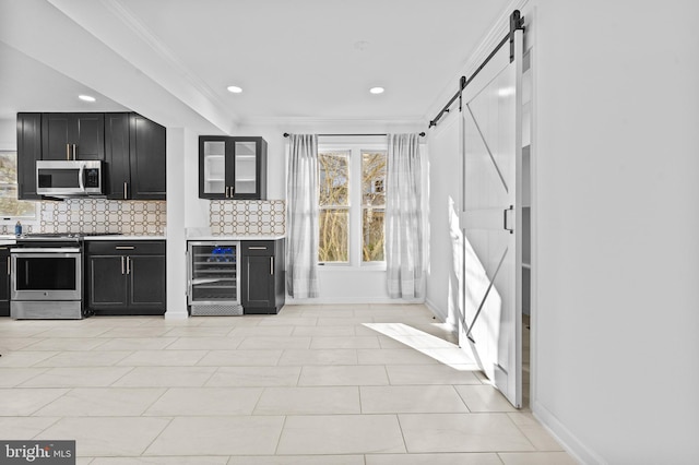 kitchen featuring wine cooler, stainless steel appliances, a barn door, and dark cabinets