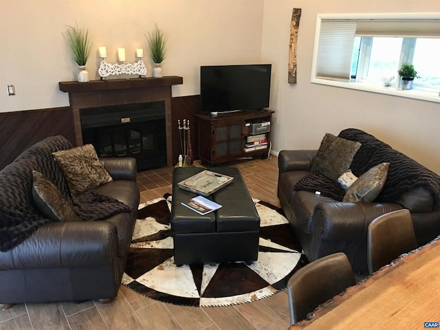 living area with a tiled fireplace and wood tiled floor