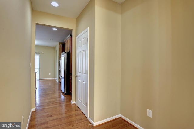 hall featuring recessed lighting, light wood-style flooring, and baseboards