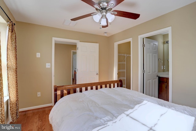 bedroom with a spacious closet, visible vents, baseboards, light wood-type flooring, and a closet