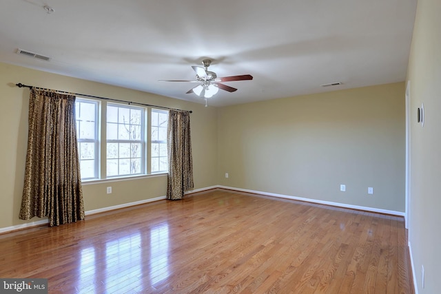 spare room with visible vents, light wood-style flooring, and baseboards