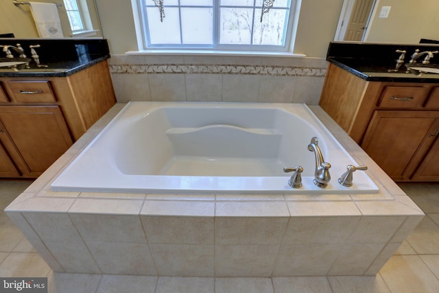 full bath featuring a sink, two vanities, a bath, and tile patterned floors