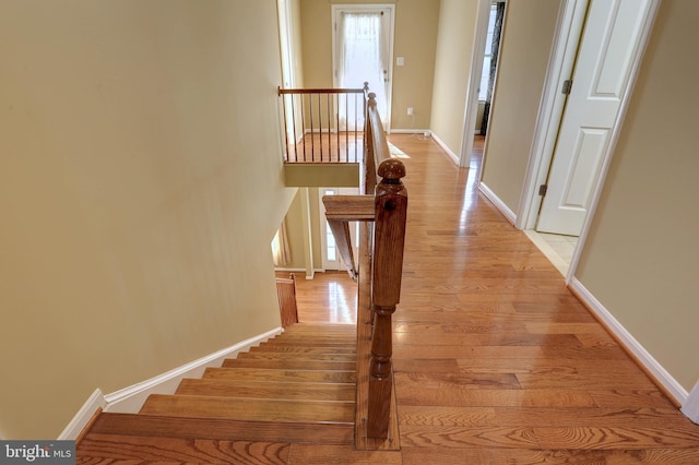 interior space featuring an upstairs landing, light wood-type flooring, and baseboards