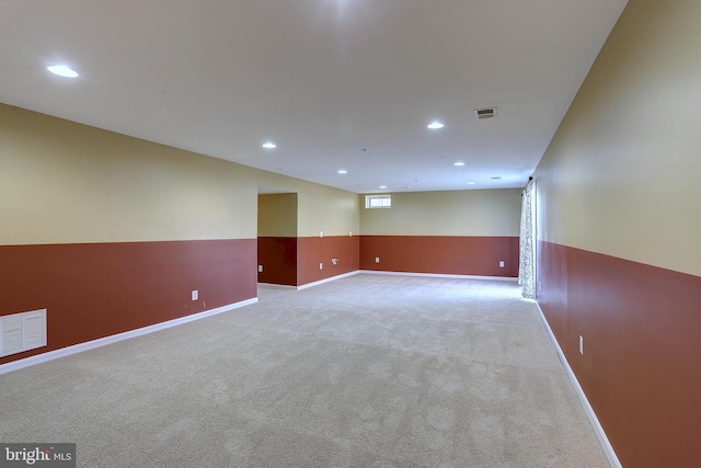 empty room featuring a wainscoted wall, carpet, recessed lighting, and visible vents