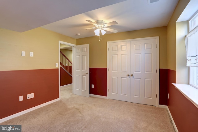 unfurnished bedroom with light carpet, baseboards, and a closet