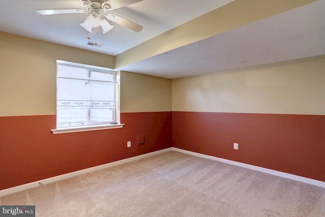 carpeted empty room featuring visible vents, baseboards, and a ceiling fan