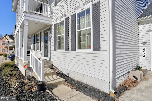 view of side of home with a balcony and crawl space