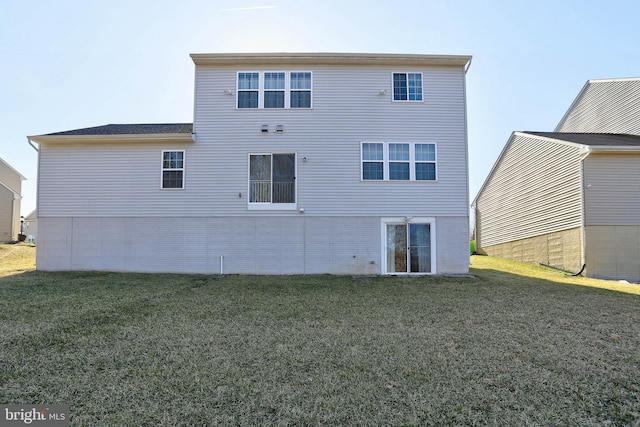 rear view of property featuring a lawn