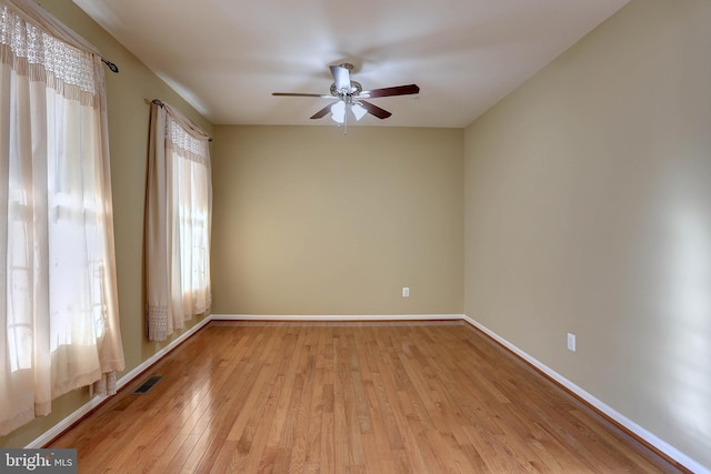 spare room with plenty of natural light, visible vents, light wood-type flooring, and baseboards