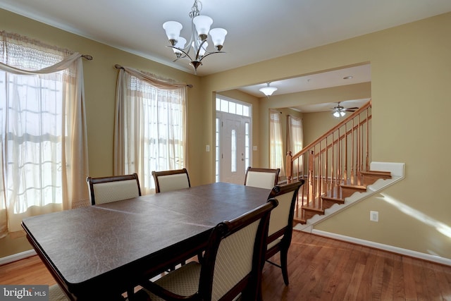 dining area with stairway, a notable chandelier, light wood-style flooring, and baseboards