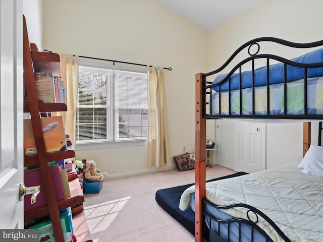 carpeted bedroom with lofted ceiling