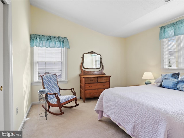 bedroom featuring multiple windows, baseboards, and light carpet