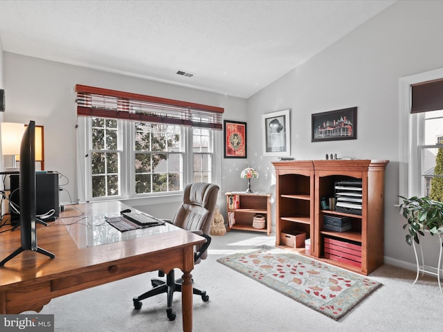 office area with lofted ceiling, carpet flooring, baseboards, and visible vents