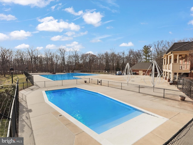 community pool featuring a patio area and fence