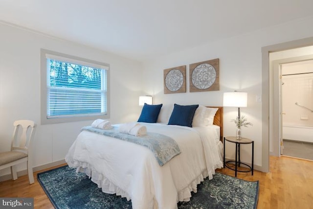 bedroom featuring baseboards and wood finished floors