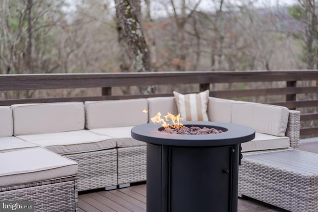 wooden terrace featuring an outdoor living space with a fire pit