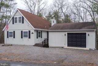 view of front of property with an attached garage and gravel driveway