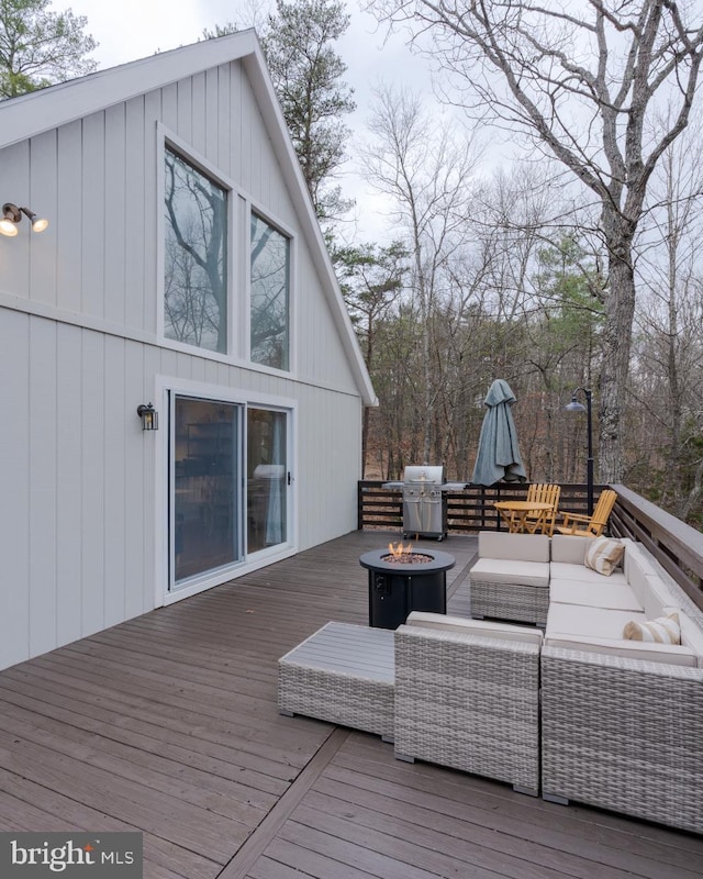 deck featuring grilling area and an outdoor living space with a fire pit