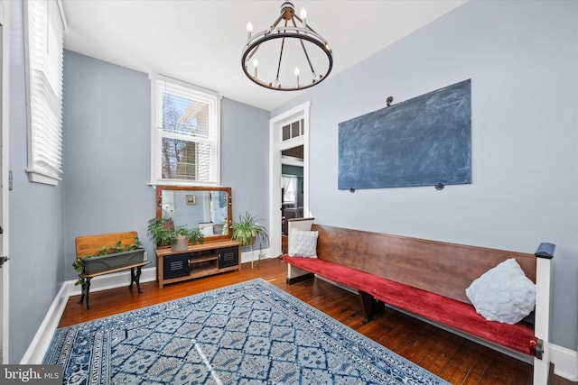 sitting room featuring baseboards, a notable chandelier, and hardwood / wood-style floors