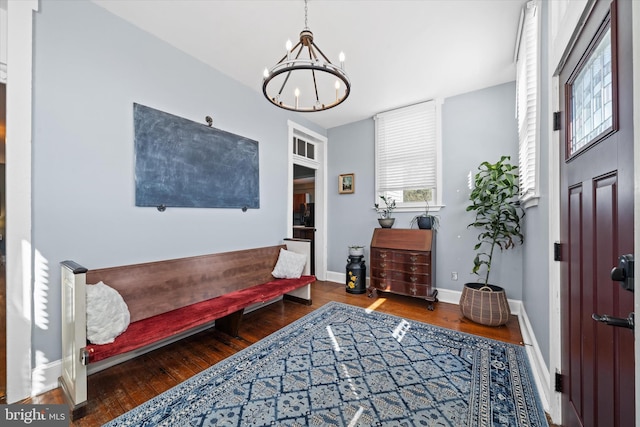 foyer entrance with a notable chandelier, wood finished floors, and baseboards