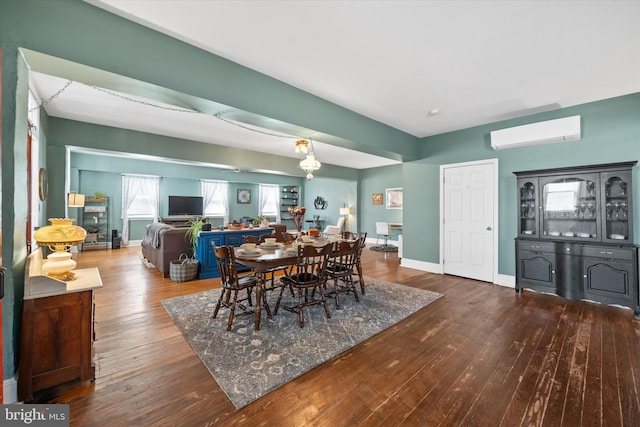 dining room featuring baseboards, hardwood / wood-style floors, and a wall unit AC