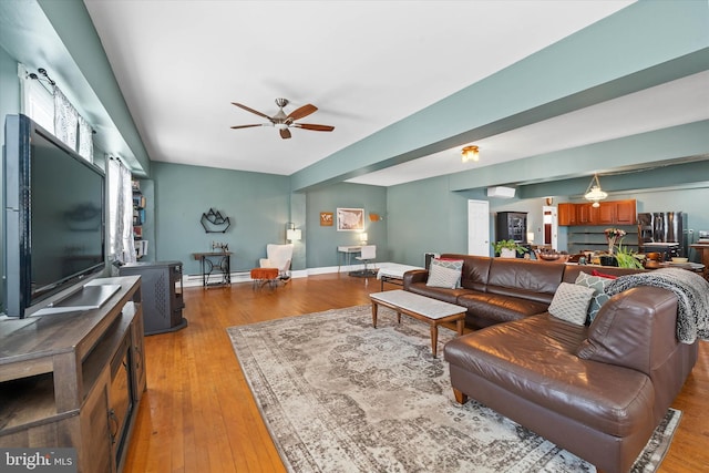 living room with hardwood / wood-style floors, a ceiling fan, baseboards, and a baseboard radiator