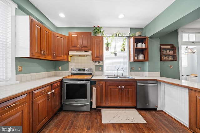 kitchen with under cabinet range hood, plenty of natural light, appliances with stainless steel finishes, and a sink