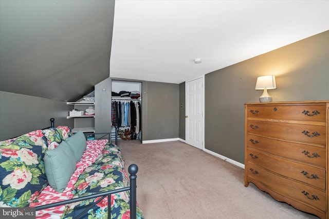 interior space featuring a closet, baseboards, light colored carpet, and lofted ceiling