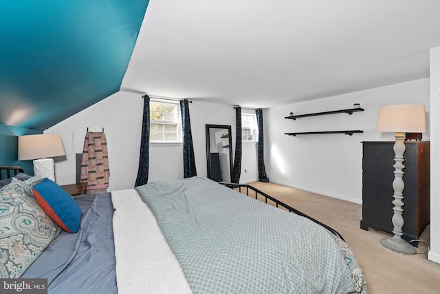 carpeted bedroom featuring lofted ceiling and baseboards