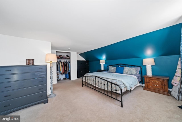 carpeted bedroom with a closet and vaulted ceiling