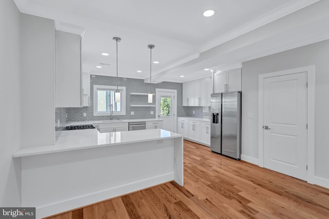 kitchen featuring white cabinets, appliances with stainless steel finishes, light wood-type flooring, and light countertops