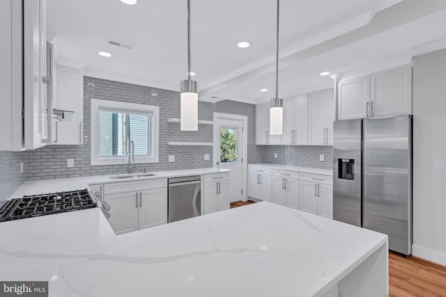 kitchen featuring visible vents, light wood-style flooring, a sink, decorative backsplash, and appliances with stainless steel finishes