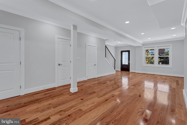 unfurnished living room featuring baseboards, light wood-style flooring, recessed lighting, ornamental molding, and stairs