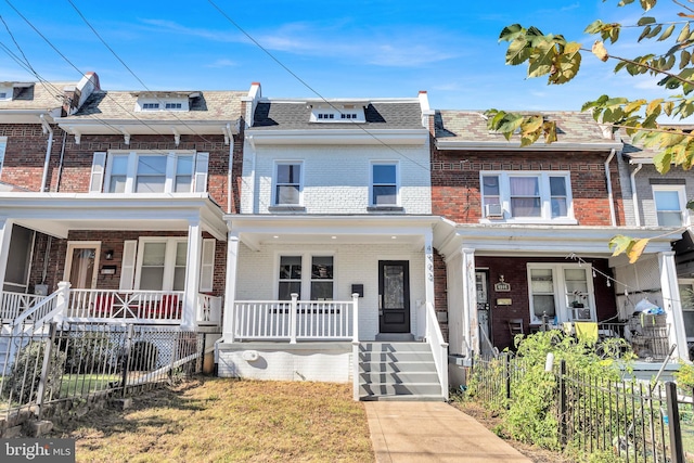 multi unit property with fence, covered porch, and brick siding