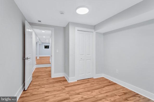 unfurnished bedroom with light wood-style flooring, baseboards, and a closet