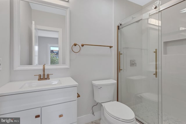 bathroom featuring vanity, toilet, baseboards, and a stall shower