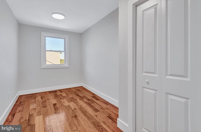 empty room with light wood-style flooring and baseboards