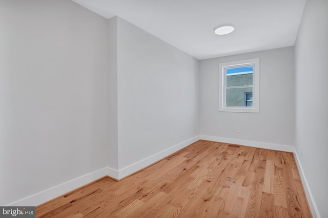 unfurnished room with baseboards and light wood-style flooring