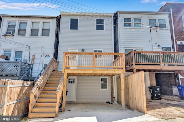 back of house with stairs, a deck, and fence