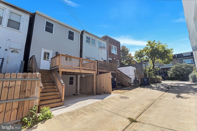 back of property with stairs, a deck, and a residential view