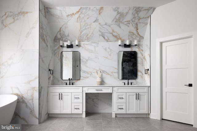 full bath featuring double vanity, a freestanding bath, and a sink