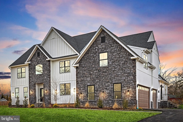 modern inspired farmhouse featuring driveway, roof with shingles, board and batten siding, and a front lawn